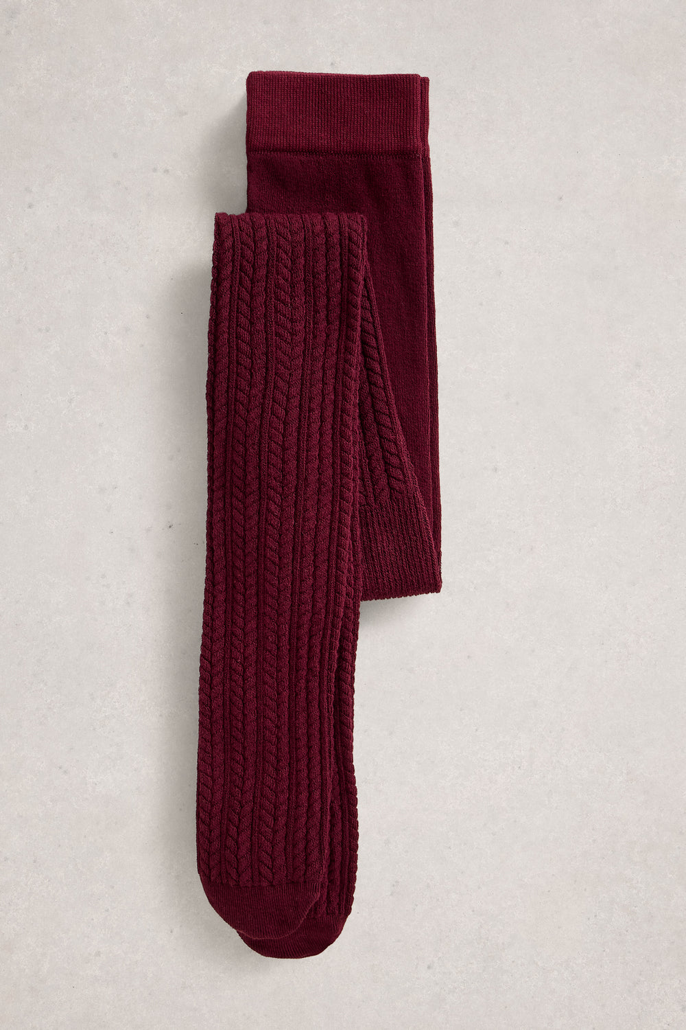 Pair of burgundy cable knit tights on a light gray background