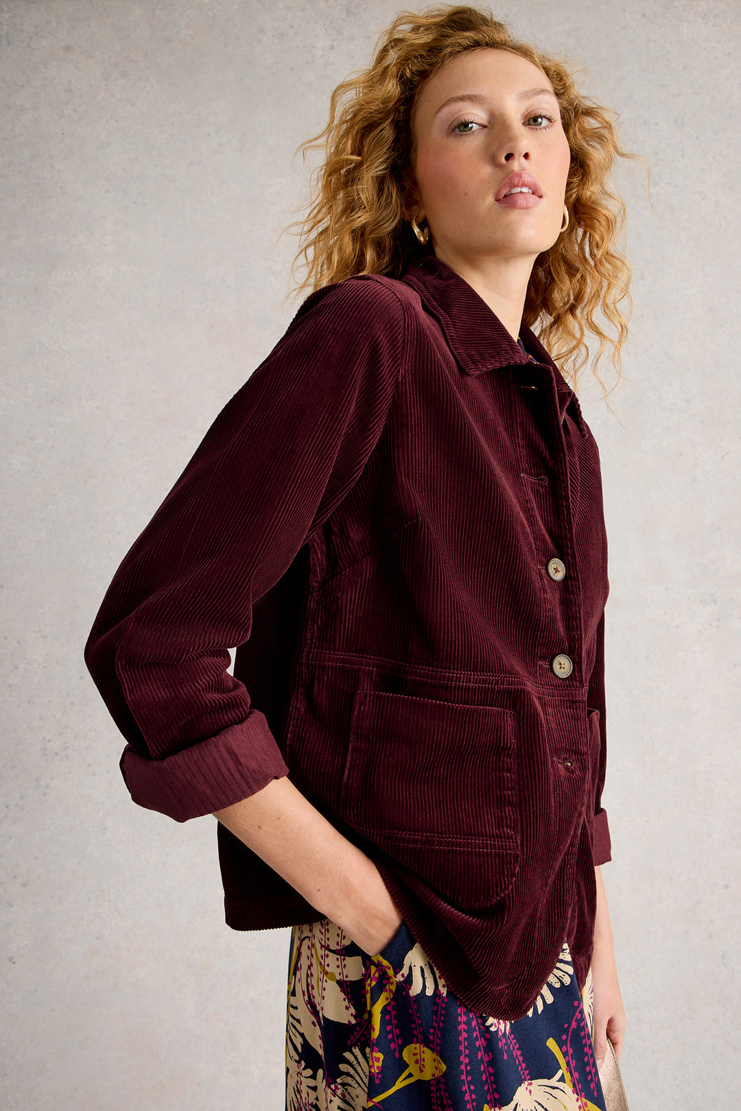 Woman wearing a burgundy jacket against a neutral background