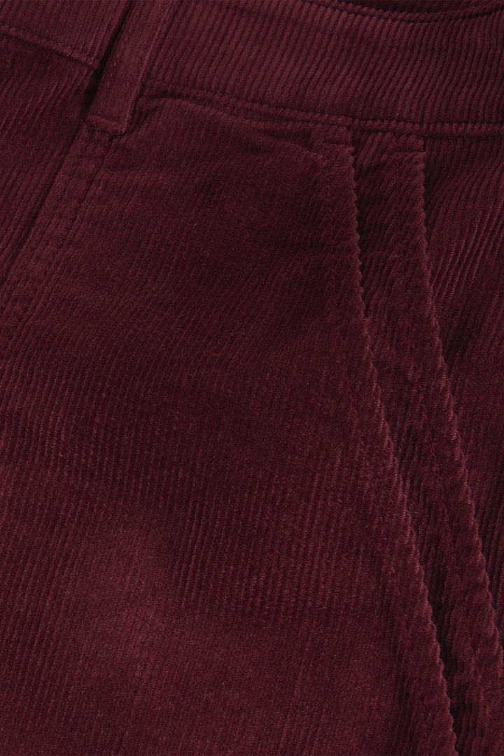 Close-up of a textured burgundy fabric with a collar.