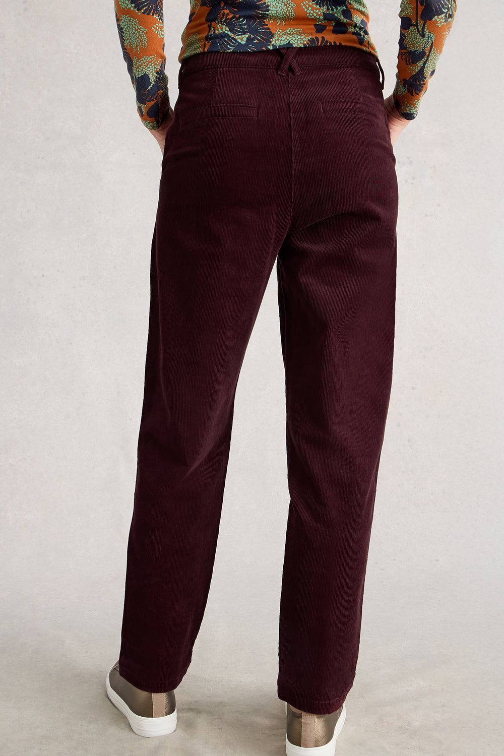 Maroon pants worn by a person on a plain background
