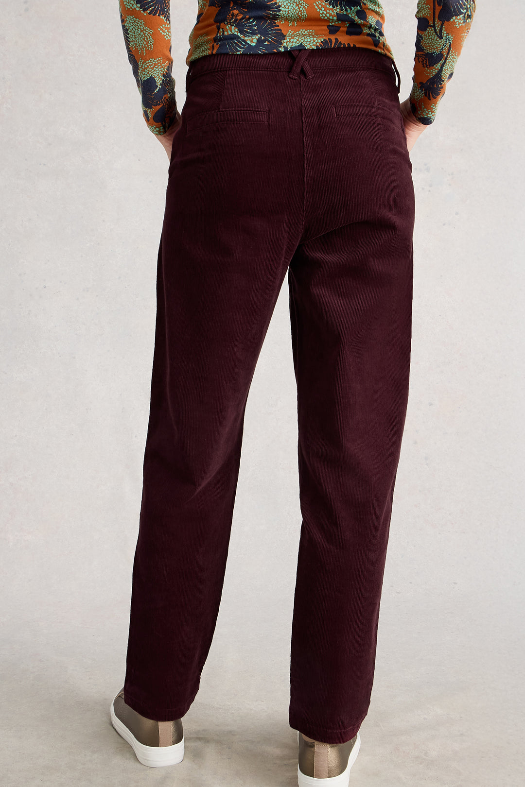 Maroon pants worn by a person on a plain background
