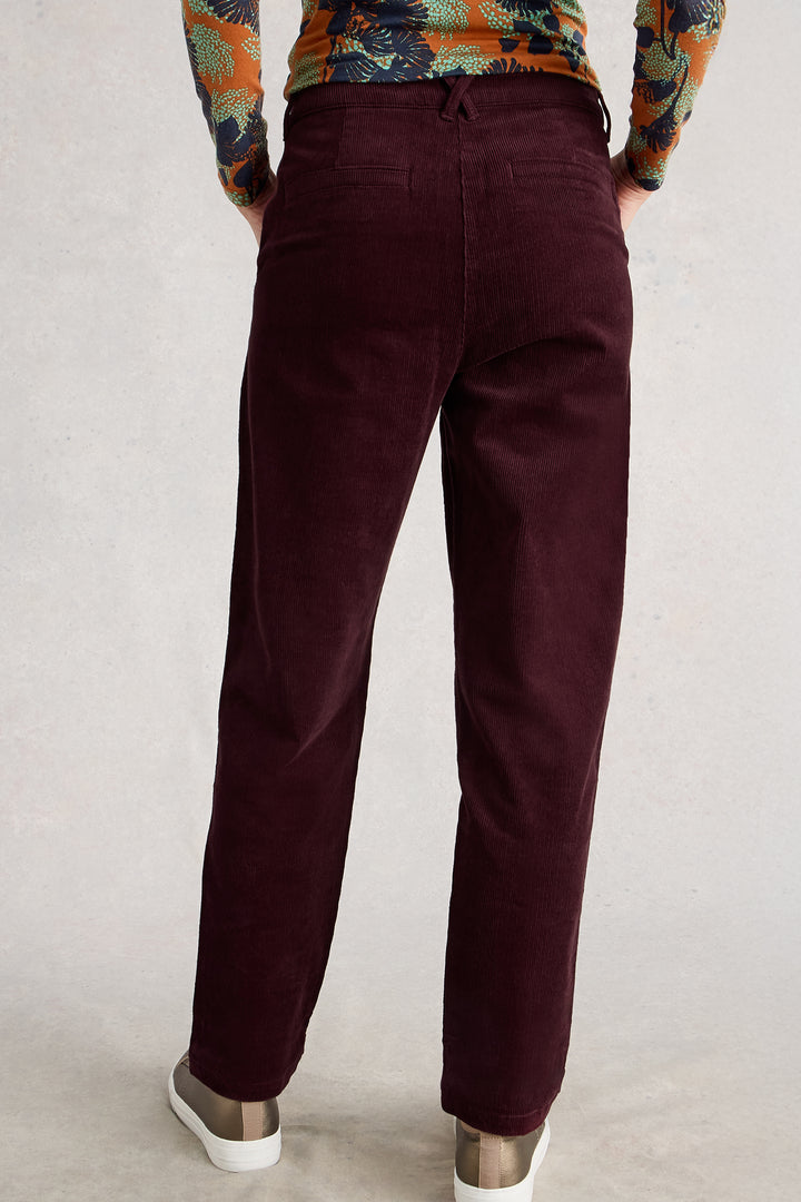 Maroon pants worn by a person on a plain background