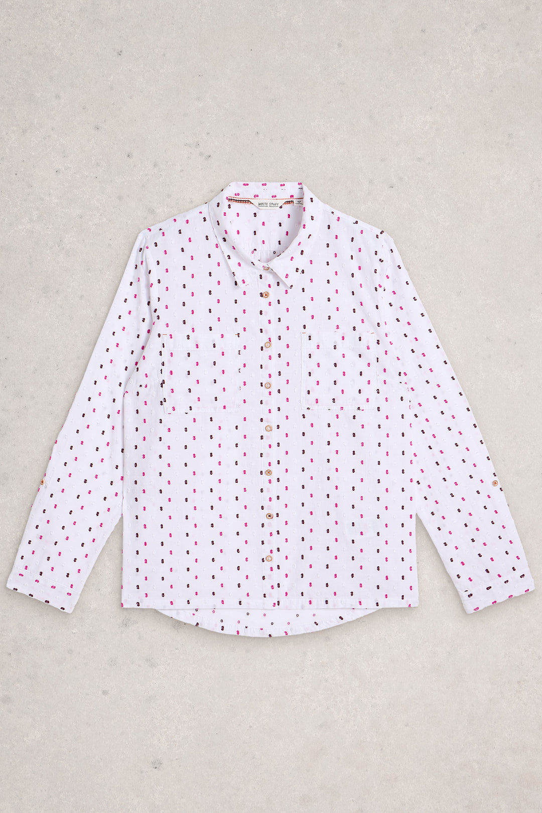 White shirt with red pattern on a beige background