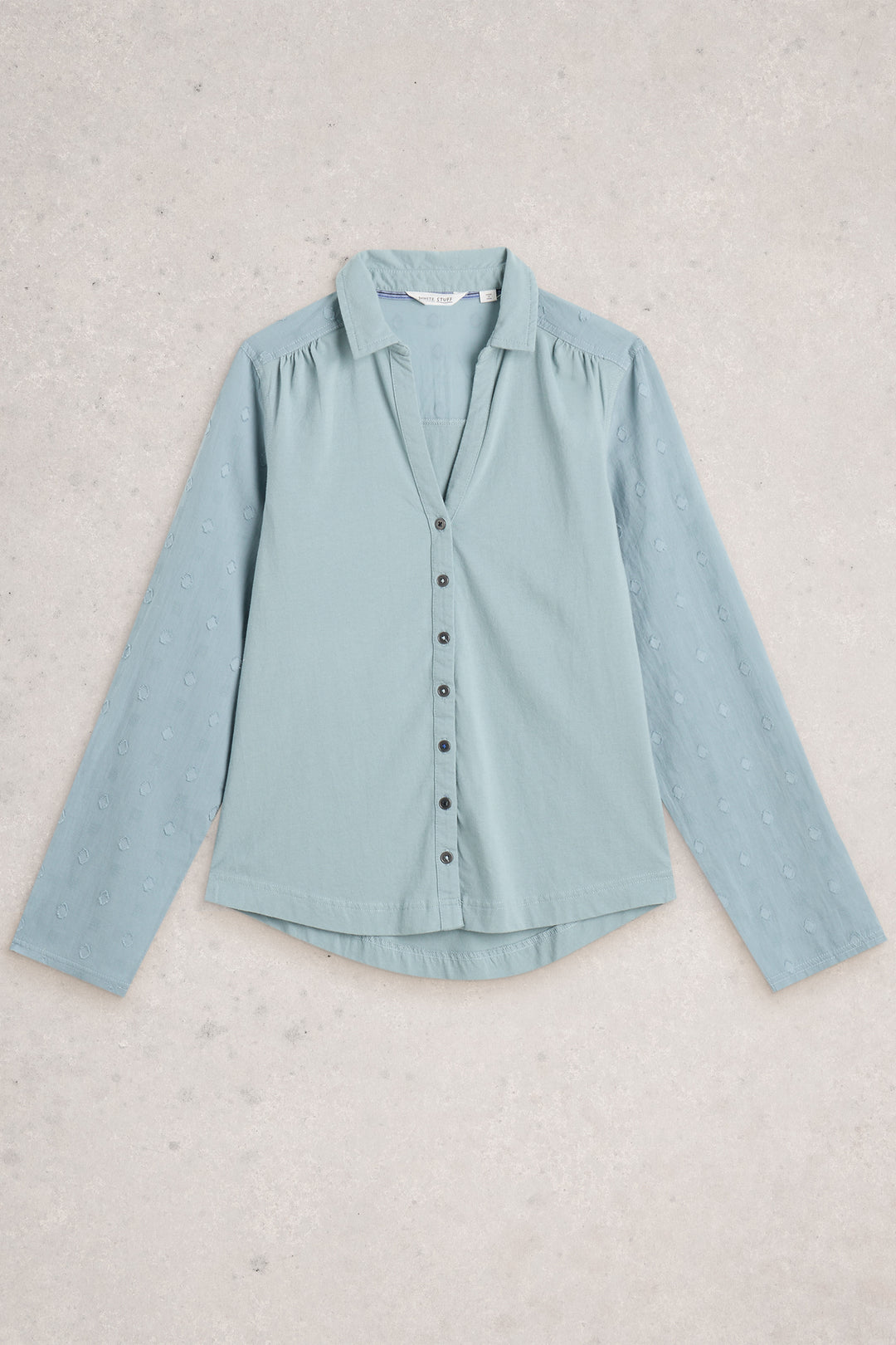 Light blue shirt on a textured beige background