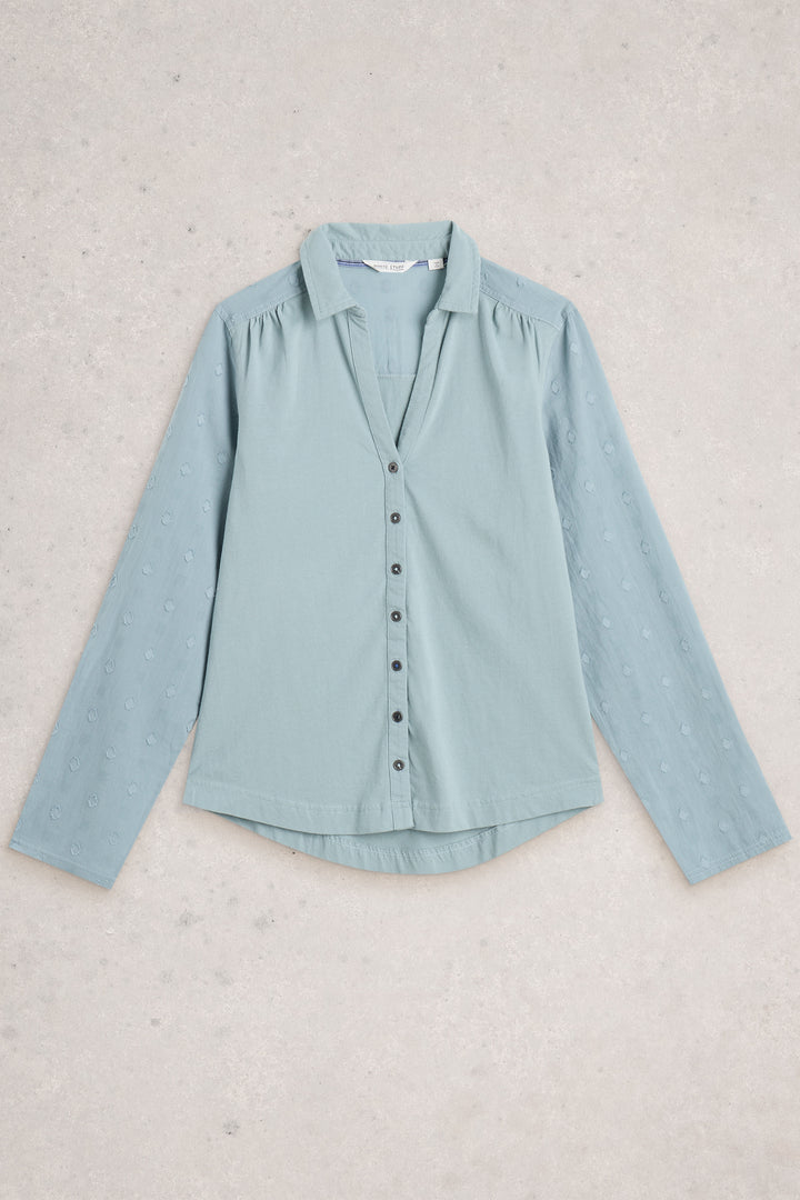 Light blue shirt on a textured beige background