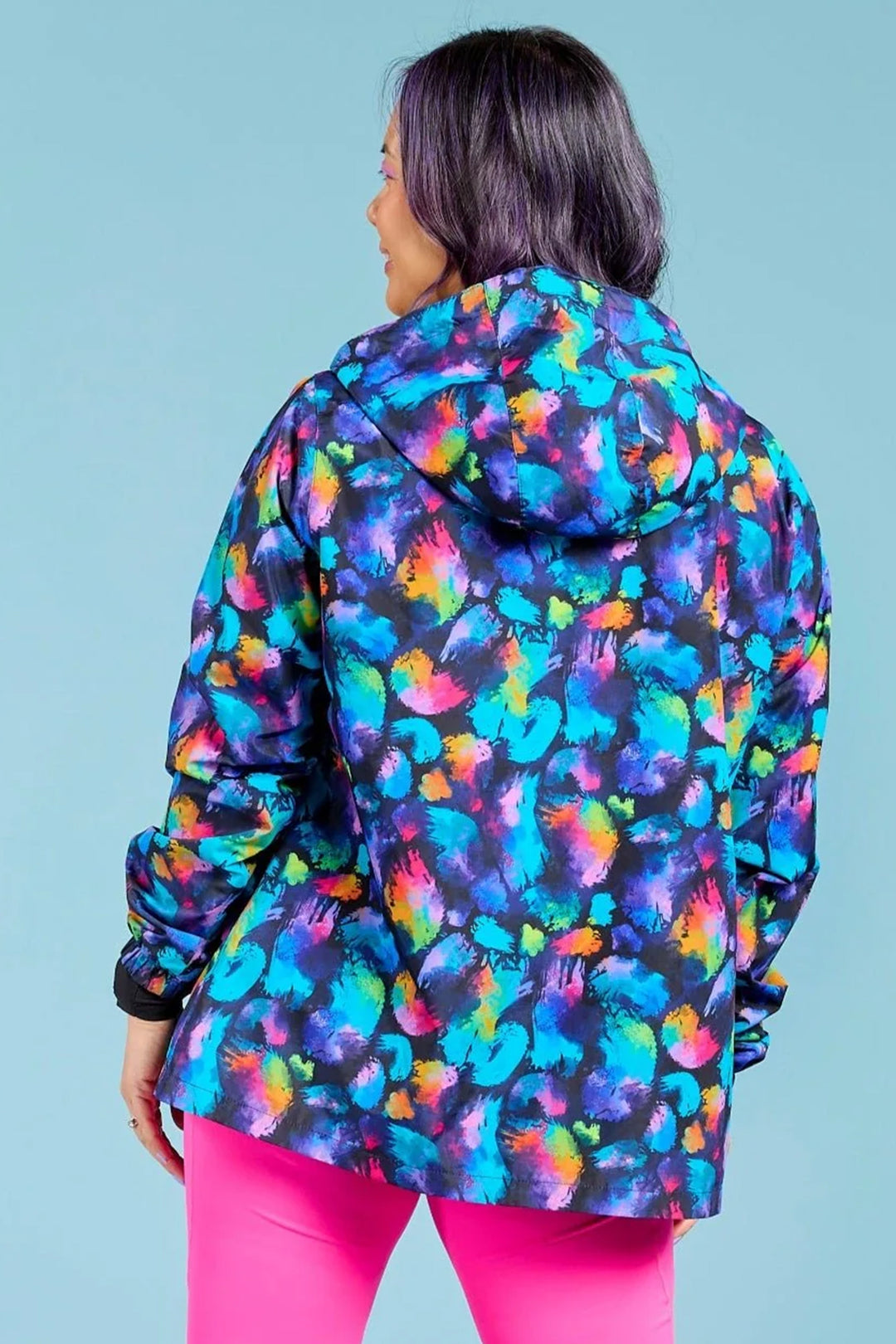 Person wearing a colorful jacket with a blue background