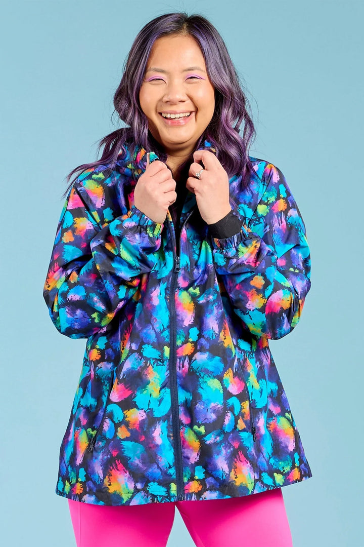 Person wearing a colorful jacket with a blue background