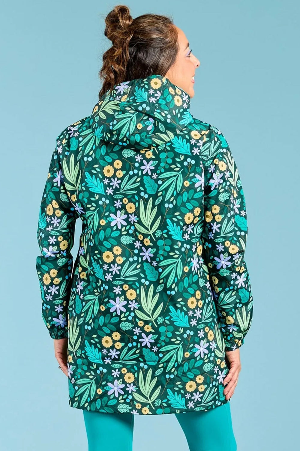 Woman wearing a floral-patterned raincoat against a blue background