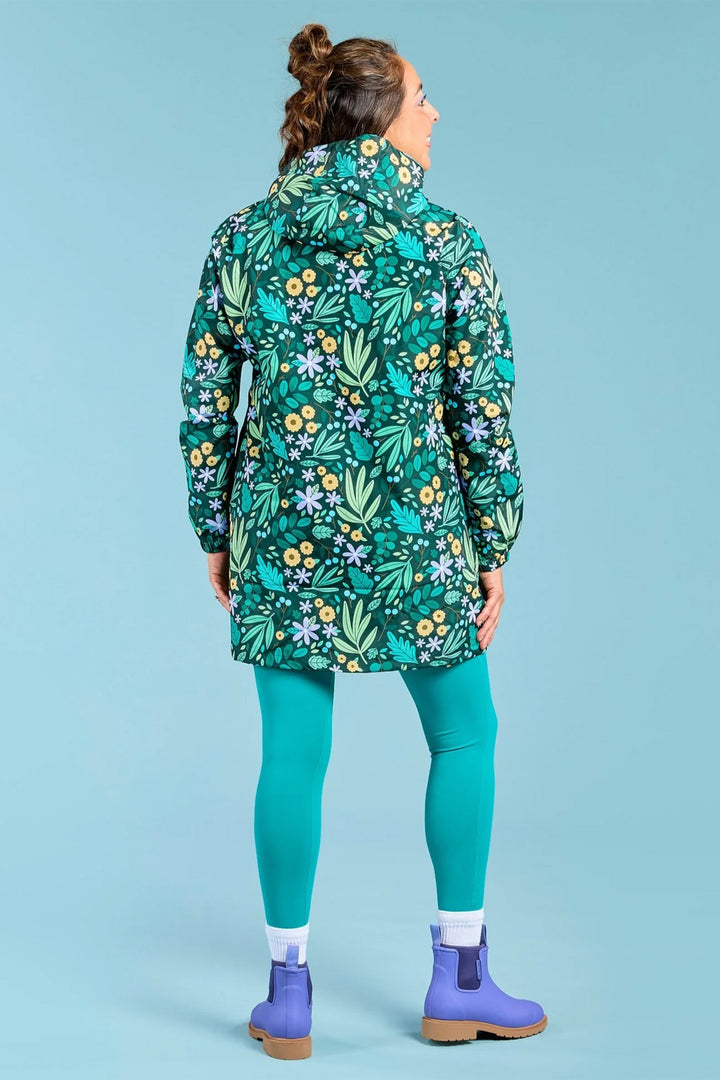 Person wearing a floral-patterned raincoat on a solid blue background