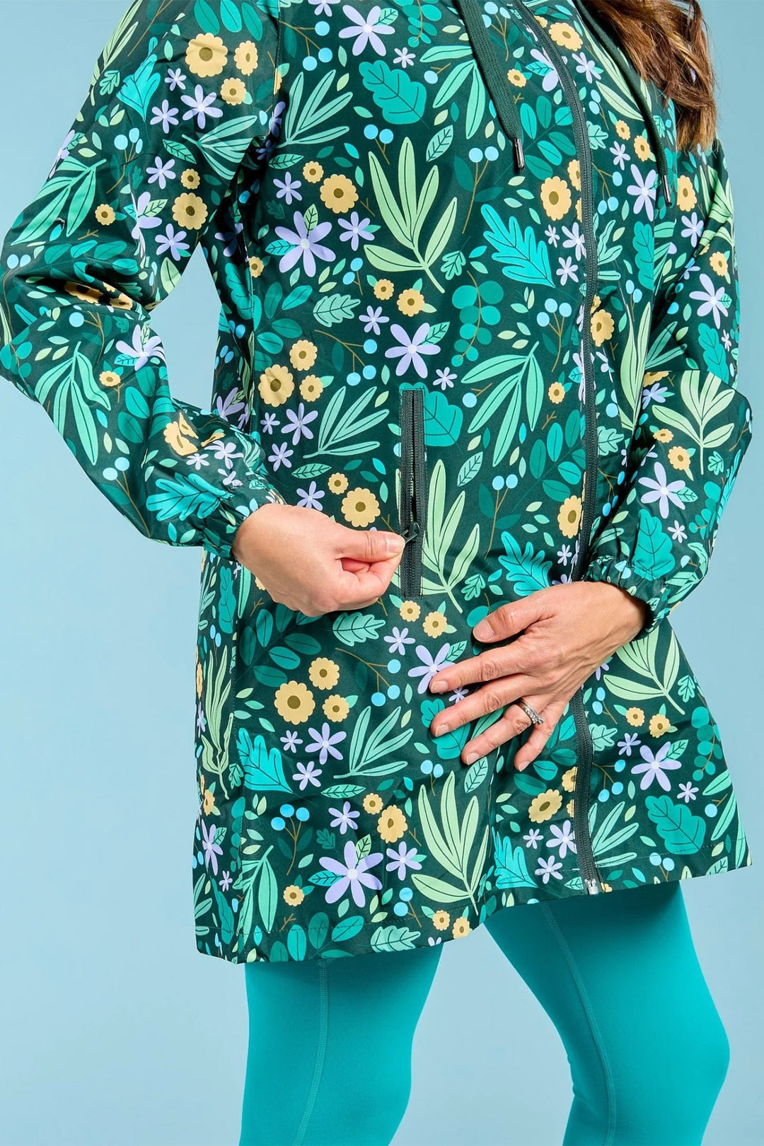 Person wearing a green floral patterned jacket against a blue background