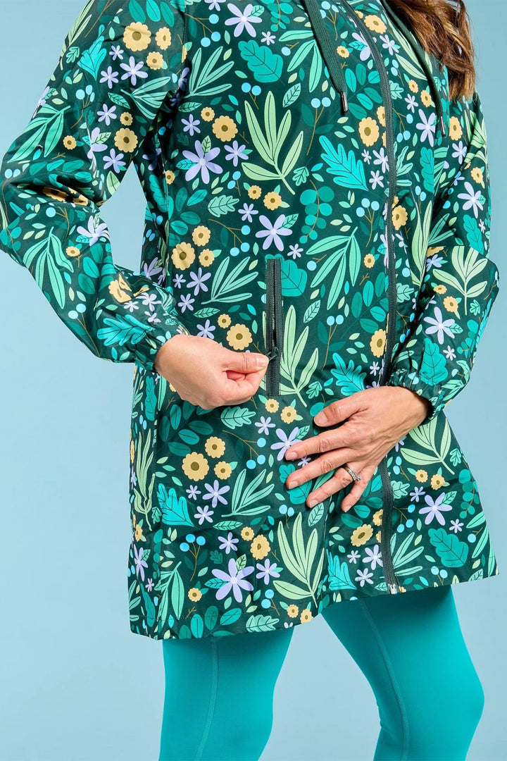 Person wearing a green floral patterned jacket against a blue background