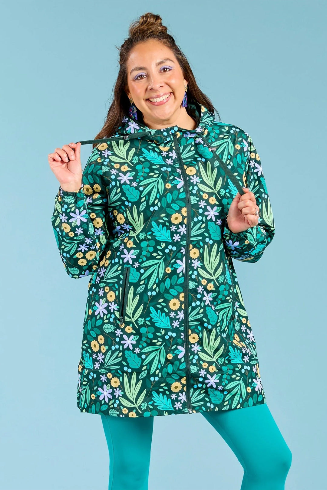 Person wearing a colorful raincoat with a leaf pattern on a blue background